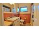 Retro bathroom featuring a pedestal sink, tiled walls, and updated fixtures at 518 Oranole Rd, Maitland, FL 32751