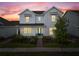 Charming two-story home with blue trim and a well-manicured lawn, illuminated by the warm colors of dusk at 6522 Rover Way, St Cloud, FL 34771