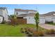 Two-story home with attached two car garage, neutral siding, solar panels, and landscaping at 6522 Rover Way, St Cloud, FL 34771