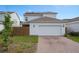 Two-story home with a two-car garage, neutral siding, solar panels, and manicured landscaping at 6522 Rover Way, St Cloud, FL 34771