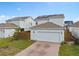 Two-story home with two-car garage, neutral siding, solar panels, and a paved driveway at 6522 Rover Way, St Cloud, FL 34771