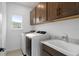 Efficient laundry room with front-load washer and dryer, upper cabinets, and a sink for added convenience at 6522 Rover Way, St Cloud, FL 34771