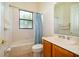Bathroom featuring a shower-tub combo, blue curtains, and wood vanity at 730 Villa Park Rd, Poinciana, FL 34759