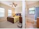 Charming bedroom with a queen-sized bed, ceiling fan, and ensuite bathroom access at 730 Villa Park Rd, Poinciana, FL 34759