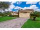 Beautiful home with a well-manicured lawn, tiled roof, and paved driveway at 730 Villa Park Rd, Poinciana, FL 34759