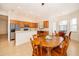 Kitchen with wood cabinetry, stainless steel appliances, tile flooring, and wood dining table with chairs at 730 Villa Park Rd, Poinciana, FL 34759