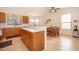 Bright kitchen featuring wood cabinetry, tile flooring, stainless sink, and an island with breakfast bar at 730 Villa Park Rd, Poinciana, FL 34759