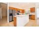 Bright kitchen with wood cabinetry, stainless steel appliances, and island with white countertop at 730 Villa Park Rd, Poinciana, FL 34759