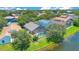 Aerial view of a property featuring screened in pool, fenced yard, mature trees, and tranquil lakeside setting at 746 Stonewyk Way, Kissimmee, FL 34744