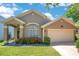 Charming single-Gathering home featuring a well-manicured lawn and a two-car garage at 746 Stonewyk Way, Kissimmee, FL 34744
