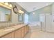 Main bathroom featuring a soaking tub, glass shower, and dual sink vanity at 746 Stonewyk Way, Kissimmee, FL 34744
