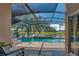 View of a screened-in pool and patio with a lake and yard in the background at 746 Stonewyk Way, Kissimmee, FL 34744