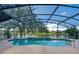 Outdoor pool in screened-in lanai, with lake and partial view of neighborhood at 746 Stonewyk Way, Kissimmee, FL 34744