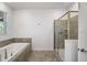 Well-lit bathroom featuring a soaking tub, glass shower, and neutral wall color at 9126 Sommerset Hills Dr, Davenport, FL 33896