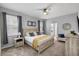 Comfortable bedroom with a ceiling fan, large bed, decorative window treatments, and accent chair at 9126 Sommerset Hills Dr, Davenport, FL 33896