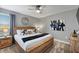 Bedroom with wooden bed frame, side tables, modern light fixtures, and neutral walls at 9126 Sommerset Hills Dr, Davenport, FL 33896