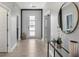 Bright hallway with tiled floor, white doors, a decorative mirror, and modern accent pieces at 9126 Sommerset Hills Dr, Davenport, FL 33896