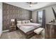 Comfortable main bedroom with a ceiling fan, king bed, accent wall, and a bench at 9126 Sommerset Hills Dr, Davenport, FL 33896