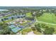 Aerial view of a community featuring a clubhouse, pool, tennis courts, golf course, and lake at 9905 Lanai View Ct, Windermere, FL 34786