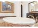 Bright bathroom features a marble countertop, framed artwork, and an elegant, free-standing white tub at 9905 Lanai View Ct, Windermere, FL 34786