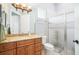 Bathroom with a wood vanity, granite countertop, toilet, and a glass-enclosed shower at 9905 Lanai View Ct, Windermere, FL 34786