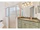 Bathroom featuring a glass shower, vanity with granite countertop, and decorative light fixture at 9905 Lanai View Ct, Windermere, FL 34786