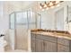 Bathroom features a glass door shower and gray vanity with granite countertop at 9905 Lanai View Ct, Windermere, FL 34786