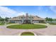 Front view of the community clubhouse featuring manicured lawn, circular driveway, and flag poles at 9905 Lanai View Ct, Windermere, FL 34786
