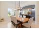 Formal dining room features a long, raw-edge wooden table and modern lighting at 9905 Lanai View Ct, Windermere, FL 34786