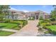 Elegant estate home featuring manicured lawns, a circular driveway, and stone and stucco facade at 9905 Lanai View Ct, Windermere, FL 34786