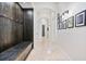 Inviting hallway with travertine floors, arched doorways, and a custom wood mud bench with storage at 9905 Lanai View Ct, Windermere, FL 34786
