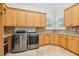 Bright laundry room with stainless steel appliances, granite countertops, custom cabinets, and plantation shutters at 9905 Lanai View Ct, Windermere, FL 34786