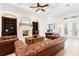 Elegant living room with fireplace, ceiling fan, hardwood floors, and comfortable leather sofas at 9905 Lanai View Ct, Windermere, FL 34786