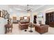 Spacious living room with tray ceilings, travertine floors, fireplace, and comfortable leather seating at 9905 Lanai View Ct, Windermere, FL 34786