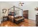 Spacious main bedroom with wooden floors, canopy bed, and detailed wooden furniture at 9905 Lanai View Ct, Windermere, FL 34786