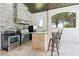 Outdoor kitchen features stone accents, stainless steel appliances and a bar area, perfect for entertaining at 9905 Lanai View Ct, Windermere, FL 34786