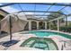 Beautiful pool area with a spa, screened enclosure, and lush landscaping at 9905 Lanai View Ct, Windermere, FL 34786