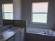 Bright bathroom featuring dual sinks, a soaking tub, and plenty of natural light at 11039 Prairie Hawk Dr, Orlando, FL 32837