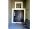 Inviting entryway featuring a black front door with sidelights, complemented by a transom window and a wrought iron bench at 11039 Prairie Hawk Dr, Orlando, FL 32837