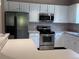 Well-equipped kitchen featuring stainless steel appliances, white cabinetry, and a breakfast bar for casual dining at 11039 Prairie Hawk Dr, Orlando, FL 32837