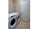 Well-equipped laundry room with modern washer and dryer, convenient shelving, and tile flooring at 11039 Prairie Hawk Dr, Orlando, FL 32837