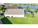 Backyard featuring a lawn, screened-in pool, and view of a tranquil pond at 1014 Prey Ct, Kissimmee, FL 34746