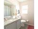 Bright bathroom featuring a granite-topped vanity, stylish mirror, and shower with neutral tones at 1014 Prey Ct, Kissimmee, FL 34746