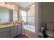 Bathroom featuring a vanity with granite countertop, mirror, shower over tub, and tiled walls at 1014 Prey Ct, Kissimmee, FL 34746