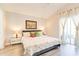 Bright bedroom with a king-size bed, floral comforter, decorative pillows, and sliding door to a balcony at 1014 Prey Ct, Kissimmee, FL 34746