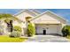Beige single-story home featuring an open carport, stucco facade, and well-manicured landscaping at 1014 Prey Ct, Kissimmee, FL 34746