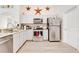 The Kitchen boasts stainless appliances, white cabinets and granite countertops at 1014 Prey Ct, Kissimmee, FL 34746