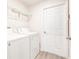 Bright laundry room featuring a white washer and dryer, wire shelving, and wood-look flooring at 1014 Prey Ct, Kissimmee, FL 34746