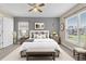 Cozy bedroom featuring a ceiling fan, neutral walls, large windows, and warm natural light at 107 Whitehall Way, Kissimmee, FL 34758