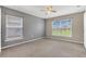 A carpeted bedroom featuring neutral walls, two windows, and natural light at 107 Whitehall Way, Kissimmee, FL 34758